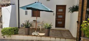 蒙特齐尔佛奈La Casetta的一个带蓝伞和桌子的庭院