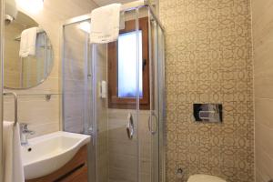 a bathroom with a shower and a sink and a toilet at Alp Suites Lavanta in Akyaka