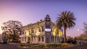 a building on a street with a palm tree at Stay at the historic Star Hotel in Sale