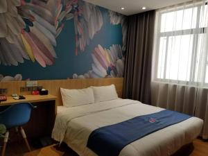 a bedroom with a bed and a desk with a window at PAI Hotel Nanchong Huaxi Normal University in Nanchong