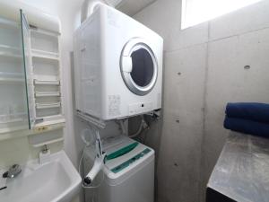 un baño con lavadora junto a un lavabo en RICCA Miyako, en Isla Miyako