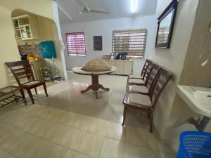 a kitchen with a table and chairs and a sink at Ariniz Homestay Beserah in Beserah