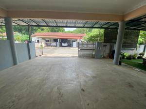 an empty garage with a gate and a building at Ariniz Homestay Beserah in Beserah +4 photos
