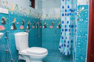 a blue tiled bathroom with a toilet and a shower at SIRENA Villa Holiday lodge in Negombo +16 photos
