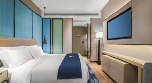 Un dormitorio con una cama grande y un televisor de pantalla plana. en Echarm Hotel Changsha Wuyi Square Railway Metro Station, en Changsha