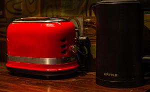 a red toaster sitting on top of a wooden table at Stylish Old Quarter Condo With Bathtub, Netflix in Hanoi