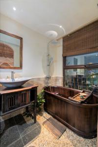 a bathroom with a wooden tub and a sink at Stylish Old Quarter Condo With Bathtub, Netflix in Hanoi