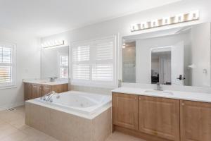 a large bathroom with a tub and two sinks at Excellent luxury living in Milton