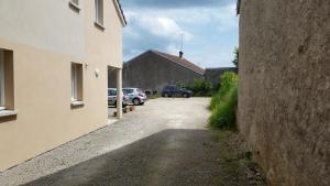 an alley between two buildings with cars parked at L'appartement Du Bien être in Damblain
