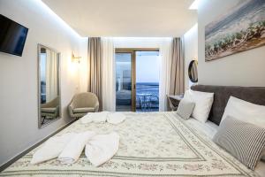 ein Schlafzimmer mit einem Bett, auf dem zwei Handtücher liegen in der Unterkunft Creta Mare Hotel in Plakias