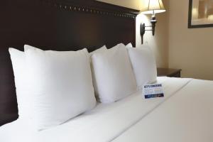 a white bed with white pillows and a sign on it at Grand Legacy At The Park in Anaheim