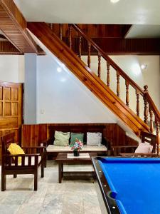 un soggiorno con tavolo da biliardo e scale di 5- Bedroom Spacious Vacation Home a Baguio