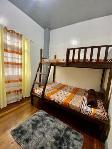 una camera con 2 letti a castello e un tappeto di 5- Bedroom Spacious Vacation Home a Baguio
