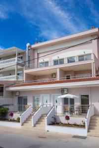 an apartment building with stairs and an umbrella at Al Mare Villas in Skala Marion