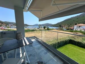 a balcony with a table and a view of the ocean at Notia Luxury Living in Porto Koufo