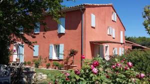 un edificio de ladrillo rojo con flores delante en Chastel, en Aix-en-Provence