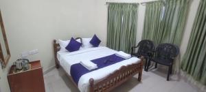 - une chambre avec un lit doté d'oreillers bleus et d'une chaise dans l'établissement Chill view cottage, à Ooty 4 autres photos