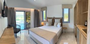 a bedroom with a large bed and a balcony at Notia Luxury Living in Porto Koufo