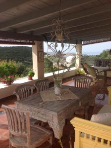 Une table et des chaises en bois sont disponibles sur la terrasse. dans l'établissement Il Suo Paradiso, à Dhavgáta