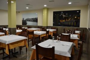 a restaurant with white tables and chairs and a large window at Hotel Jarama in Zamora