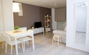 a kitchen and living room with a white table and chairs at Apto. Santa Susanna in Santa Susanna