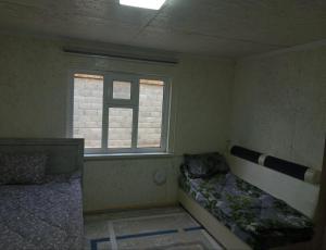 a small room with a bed and a window at Гостевой дом in Naryn