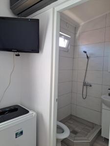 a bathroom with a toilet and a television on the wall at Vila Emy Constanta in Constanţa