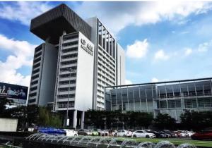a large building with cars parked in a parking lot at Studio123 at changwattana in Ban Bang Phang