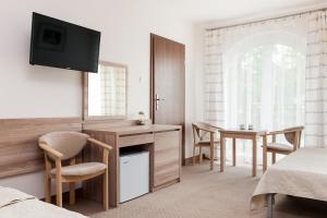 a bedroom with a desk and a table with chairs at Willa Portowa - 120 metrów od plaży in Dziwnów