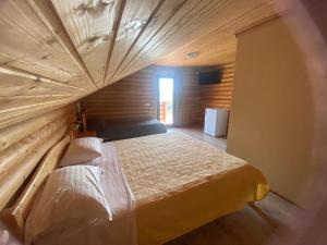 a bedroom with a large bed with a wooden ceiling at Woodvillage on the Blacksea in Costinesti