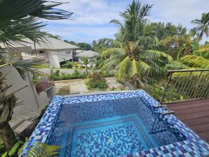 a swimming pool in a yard with palm trees at Moulin Kann Villas in Mahe