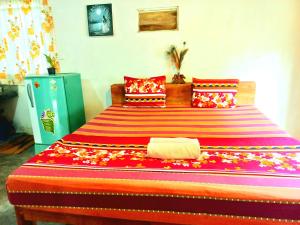 Mount Rest Villa في هيكادوا: غرفة نوم مع سرير كبير مع بطانية ملونة