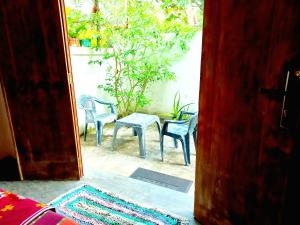 Mount Rest Villa في هيكادوا: باب مفتوح على فناء مع كراسي وطاولة