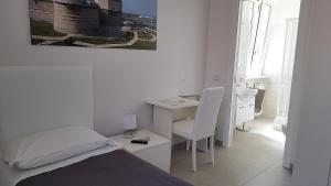 1 dormitorio con cama, escritorio y mesa en Quattro Stelle al Porto Guest House, en Civitavecchia