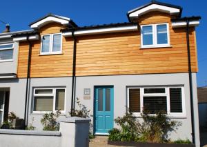 a house with a blue door and wooden facade at Ty Boia Bed & Breakfast in St. Davids