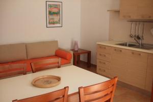 a kitchen and living room with a table and a couch at Residence La Corte in Porto Cesareo