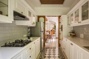 AssagaoにあるVilla Giulietta - 4BHK Villa in Assagao with Big Pvt Pool, Balcony, Dedicated Caretaker, Near Famous Cafesのタイルフロアのキッチン(白いキャビネット付)