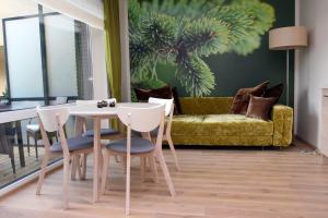 a living room with a table and chairs and a couch at Fountain apartment in Palanga