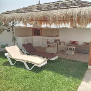 a patio with two lounge chairs and a kitchen at Villa sweet Djerba A 5km de la plage et de centre Midoun in Arkou +41 photos