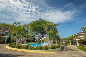 a resort with a pool and palm trees at Three Bedroom Spacious Townhome in Coco