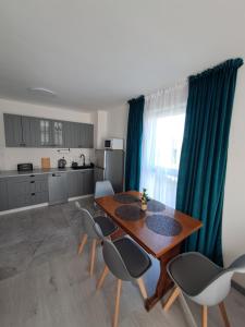 a kitchen and dining room with a wooden table and chairs at Akwarium in Międzywodzie