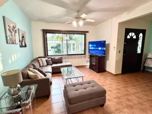 a living room with a couch and a tv at Three Bedroom Spacious Townhome in Coco