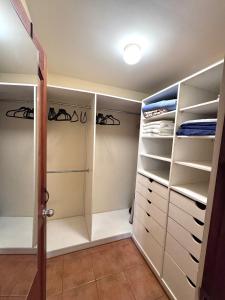 ココにあるThree Bedroom Spacious Townhomeの白い引き出しと棚付きのウォークインクローゼット