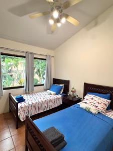 ココにあるThree Bedroom Spacious Townhomeのベッド2台と天井ファン付きの寝室
