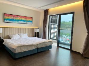a bedroom with a bed and a large window at Homestay 2pn Sapphire in Ha Long