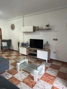 a living room with a tv and a glass coffee table at Lima in Orihuela Costa