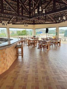 a restaurant with wooden tables and chairs and windows at Recanto Piemont in Serra Negra