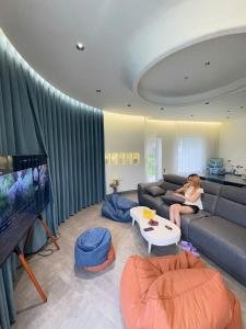 a woman sitting on a couch in a living room at Biệt thự biển có bể bơi Sea Sing Villa in Nghi Xuân