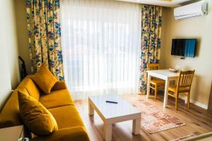 شقق ألي الفندقية في أنطاليا: غرفة معيشة مع أريكة وطاولة