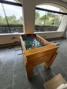 a wooden foosball table in a room with windows at Recanto Piemont in Serra Negra